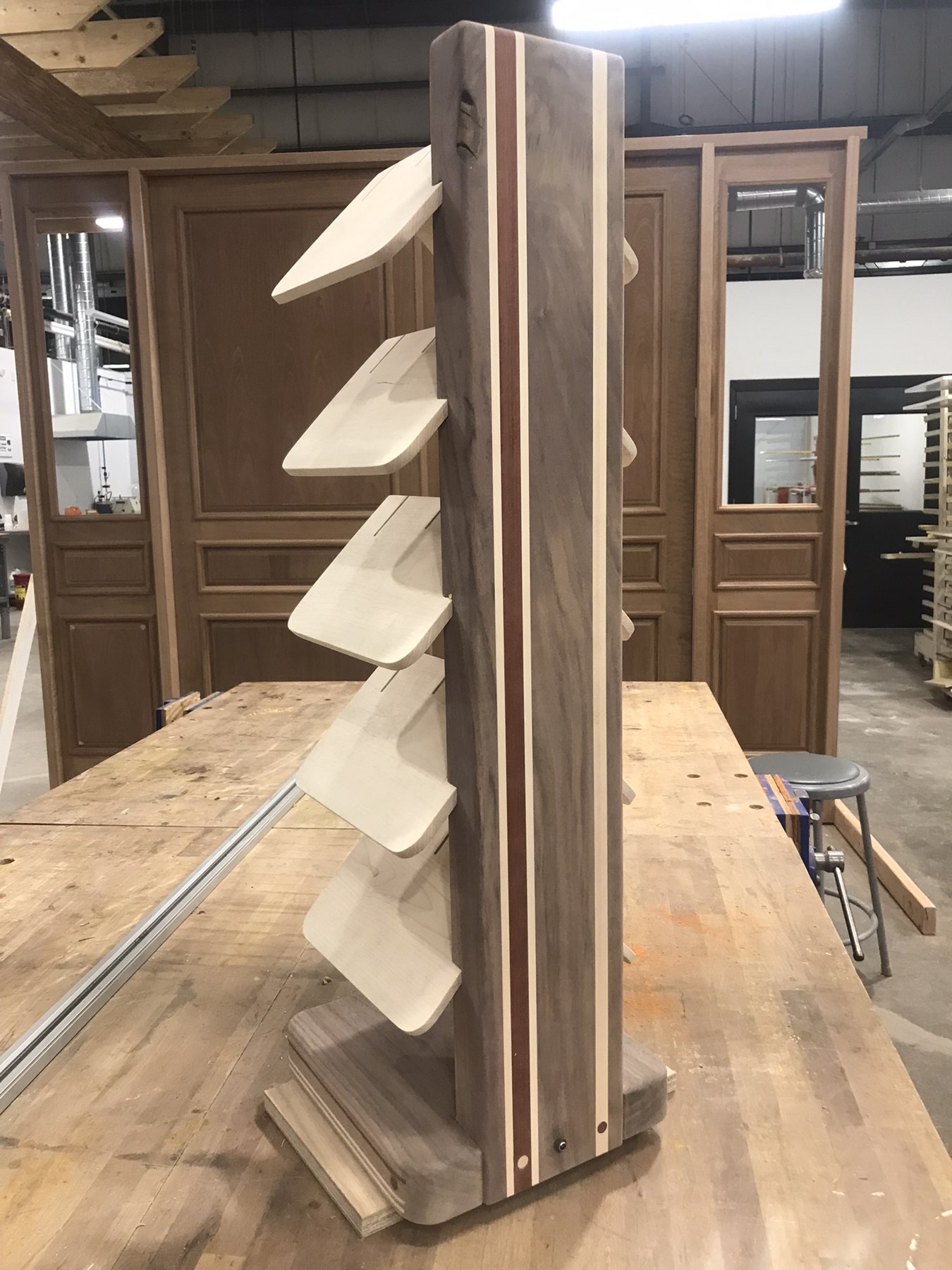 Freestanding tree-form bookshelf with angled shelves and contrasting wood spine